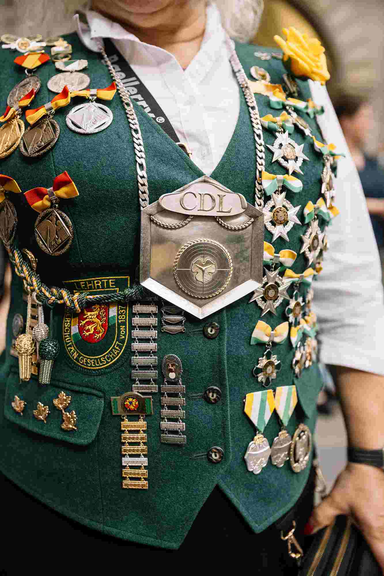 Schützenfest Hannover 2026 traditionelle grüne Schützenweste eines Schützen, geschmückt mit zahlreichen Medaillen, Abzeichen und einer großen Schützenkette der Burgdorfer Schützengesellschaft von 1837